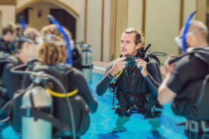 Diving instructor and students. Instructor teaches students to dive.