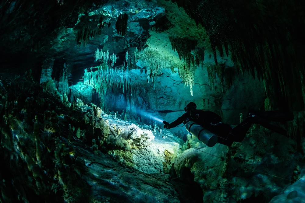cave diver instructor leading a group of divers in a mexican cenote underwater cave diver instructor leading a group of divers in a mexican cenote underwater